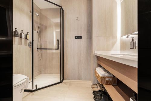 a bathroom with a shower and a toilet and a sink at Xiyada Hotel（Chongqing Guanyinqiao） in Chongqing