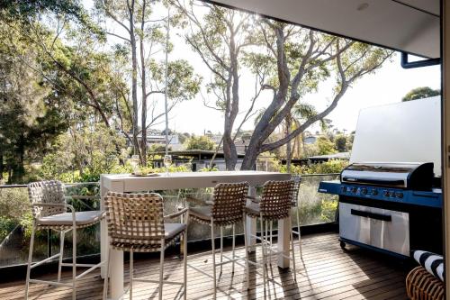 a kitchen with a table and chairs on a deck at Pandanas 17B at Mollymook Beach in Mollymook
