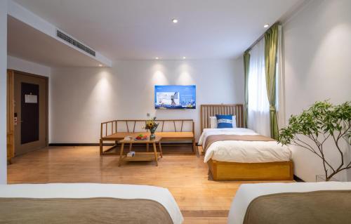 a hotel room with two beds and a table at Beijing Tangfu Nanluoguxiang Tian an Men Lama Temple San Li Tun Snack Street Hotel,Free Laundry Dry Service and Free Afternoon Tea &professional Free Tour Ticket Service with English Speaking Staff in Beijing