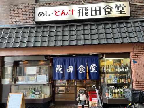 a store with a sign on the front of a building at 華宝民泊 in Wada