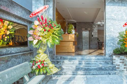 a lobby of a building with flowers in a vase at Green Hotel Vĩnh Lộc in Ho Chi Minh City