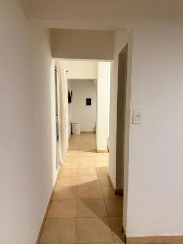 Un pasillo con paredes blancas y suelo de baldosas. en Departamento Ideal Resistencia Chaco, en Resistencia