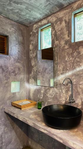 a bathroom with a black sink and a mirror at Golden Chenang Village in Pantai Cenang