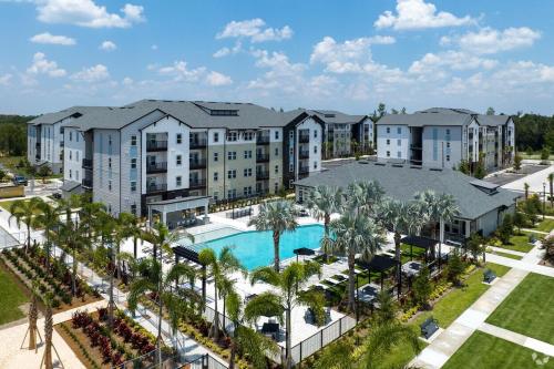 an aerial view of a resort with a pool and palm trees at Modern Oasis with King Bed, Fireworks View, 10 Minutes to Disney in Orlando