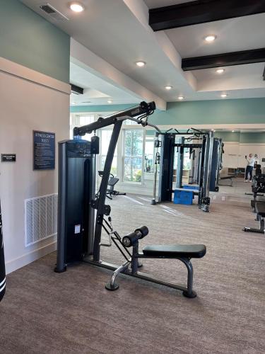 a gym with a treadmill and a bench in a room at Modern Oasis with King Bed, Fireworks View, 10 Minutes to Disney in Orlando