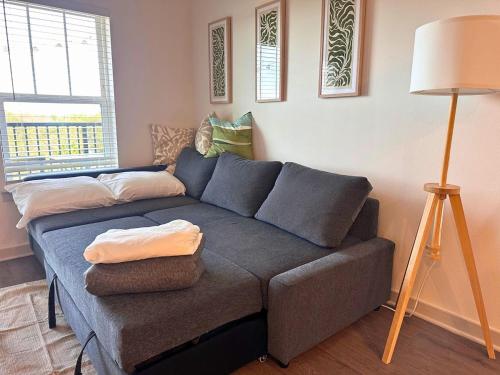 a couch in a living room with a lamp at Modern Oasis with King Bed, Fireworks View, 10 Minutes to Disney in Orlando