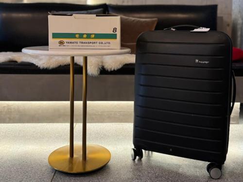 a table with a suitcase and a box on top of it at Kyoto ITOYA Hotel Mon in Kyoto