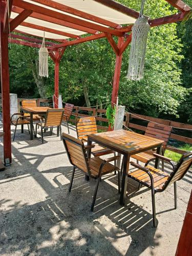 a group of tables and chairs under a pergola at Complex Adela Transfăgărășan in Cîrţişoara