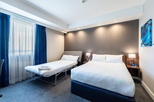 a hotel room with two beds and a window at Holiday Inn Express Aberdeen Airport by IHG in Dyce