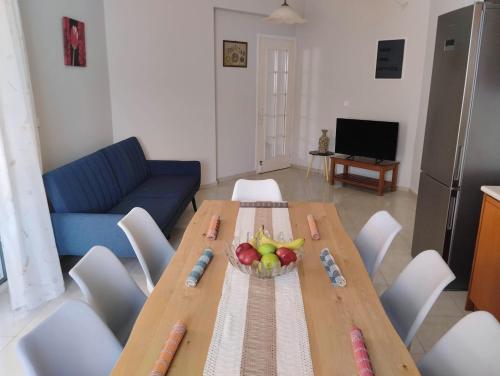 a living room with a wooden table with a bowl of fruit at Flora Beach House in Kremasti