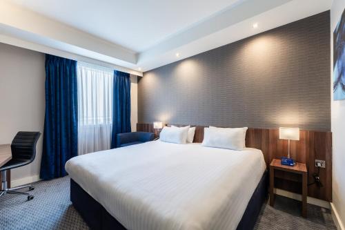 a hotel room with a large bed and a desk at Holiday Inn Express Aberdeen Airport by IHG in Dyce