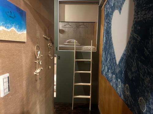 a room with a ladder and a bunk bed at 石垣ゲストハウスオハナ in Ishigaki Island