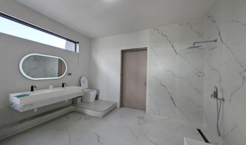 a white bathroom with a sink and a mirror at Luxury Villa with Ocean Views ! Minimum booking 1 week in Cascavelle
