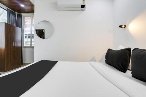 a bedroom with a white bed with black pillows at Super Collection O De Alphabet Hotel in Hyderabad
