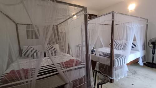 a bedroom with two bunk beds with mosquito nets at Forest Rawana homestay Ella in Ella