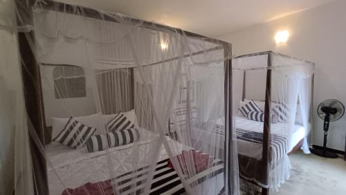 a bedroom with two bunk beds with mosquito nets at Forest Rawana homestay Ella in Ella