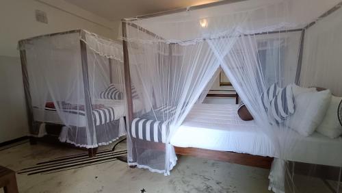 a bedroom with a canopy bed with white curtains at Forest Rawana homestay Ella in Ella
