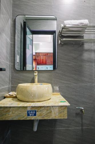 a bathroom with a sink and a mirror at Homestay PHƯỢNG HOÀNG in Lang Co