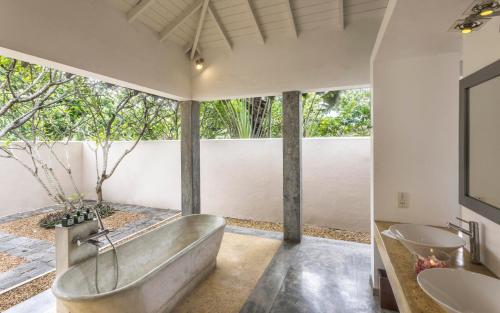 a bathroom with a tub and two sinks at The Frangipani Tree by Edwards Collection in Unawatuna
