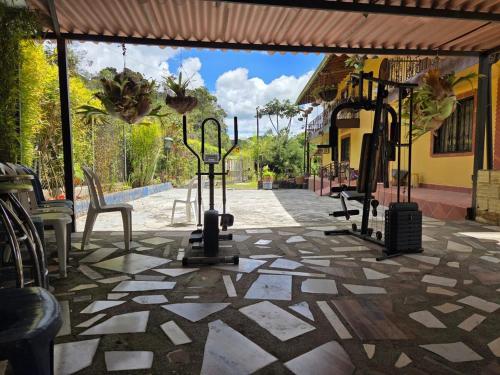 a stone patio with chairs and a gym at Finca la Martina in Barbosa