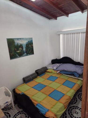 a bedroom with a bed with a colorful quilt at Finca la Martina in Barbosa