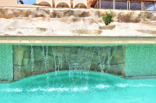 a fountain in a pool of water in a building at Grand Beach Hotel Thassos in Limenaria