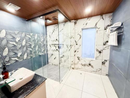 a bathroom with a sink and a shower at Monsoon Mist Kerala in Pīrmed