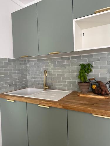 a kitchen with white cabinets and a sink at Nid Provençal - cœur de Village in Callas