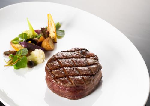 a steak on a white plate with a salad at Dolce by Wyndham Hanoi Golden Lake in Hanoi