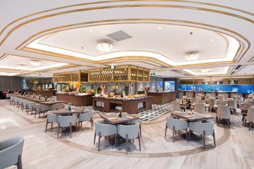 a restaurant with tables and chairs in a room at Dolce by Wyndham Hanoi Golden Lake in Hanoi