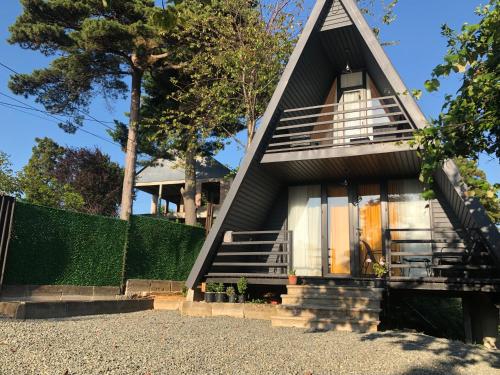 a house with a triangular roof and a staircase at Rakushki's house 2 in K'obulet'i