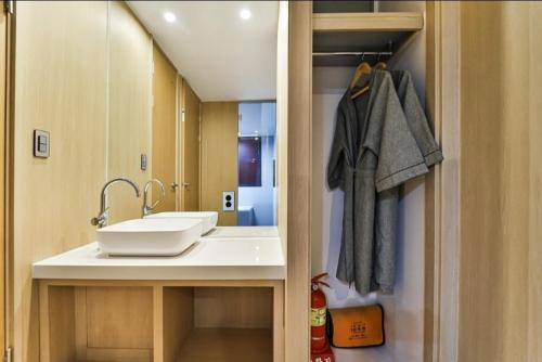 a bathroom with a sink and a mirror at The Hound Hotel Changwon Terminal in Changwon