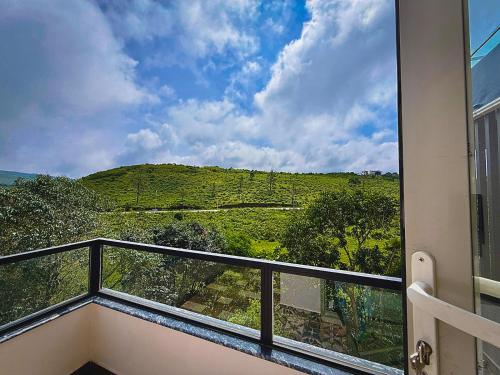 a balcony with a view of a green hill at Monsoon Mist Kerala in Pīrmed