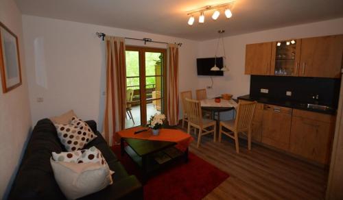 ein Wohnzimmer mit einem Sofa und einem Tisch in der Unterkunft Heulandhof in Bad Hindelang