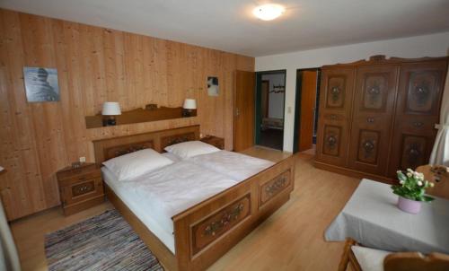 ein Schlafzimmer mit einem großen Bett und Holzwänden in der Unterkunft Heulandhof in Bad Hindelang