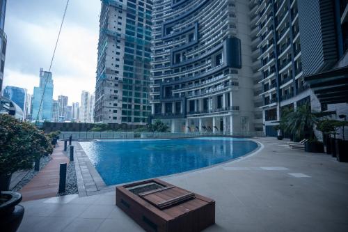 a swimming pool in a city with tall buildings at Elite Pod Manila in Manila