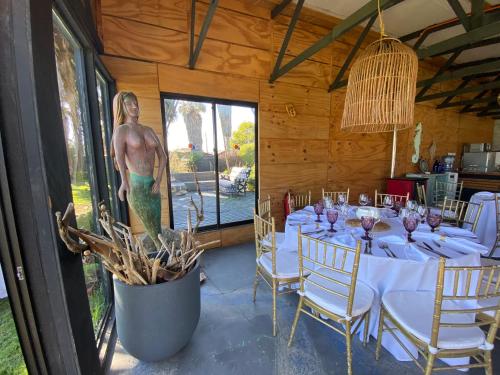 a dining room with a table and a statue of a man at Hotel Trocadero in Concón