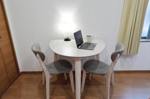 a white table with a laptop on it with two chairs at Life Town Shinkoiwa in Tokyo