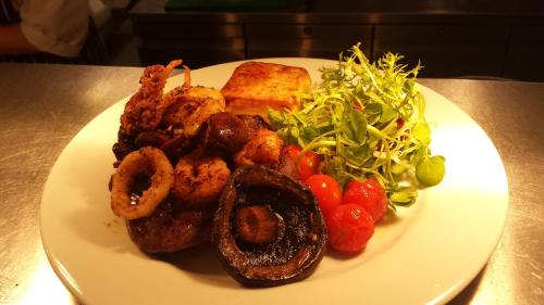 a plate of food with meat and vegetables on a table at The Poltimore Inn in North Molton
