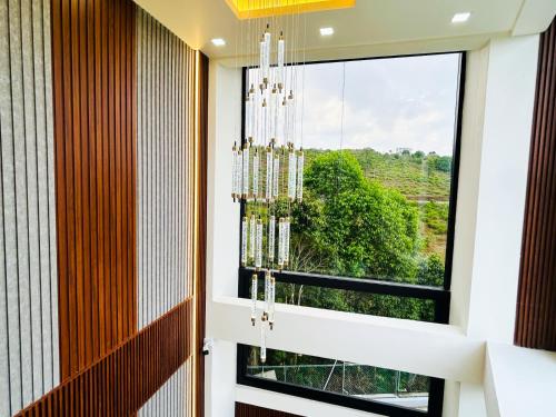 a room with a large window and a chandelier at Monsoon Mist Kerala in Pīrmed