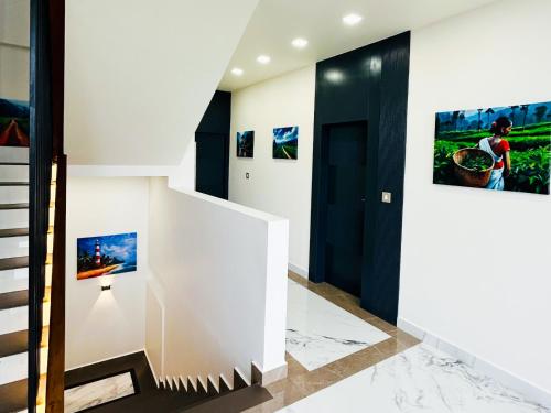 a staircase in a house with paintings on the wall at Monsoon Mist Kerala in Pīrmed