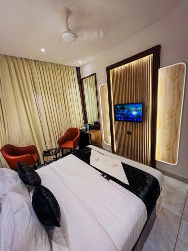 a hotel room with a bed and a television at Hotel Ocean Residency Thane West in Thane
