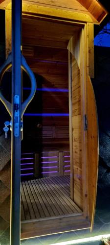 a wooden platform with a door in a building at Minijos Slėnis Ant Minijos upės kranto Pirtis jaccuzi Privatus namas Šeimai in Kalviai