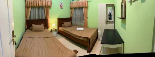 a small room with two beds and a mirror at Asoka Homestay Yogyakarta in Demangan