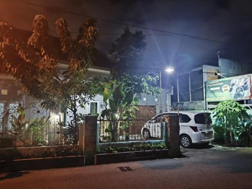 a white car parked in front of a house at night at Asoka Homestay Yogyakarta in Demangan