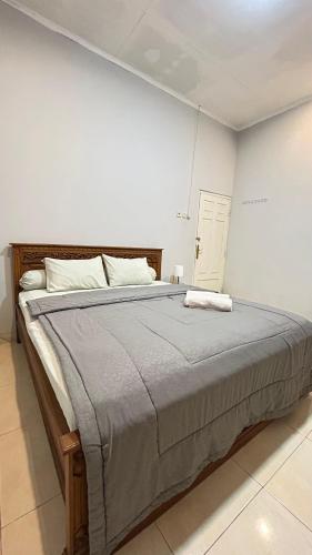 a bedroom with a large bed with a gray blanket at Asoka Homestay Yogyakarta in Demangan
