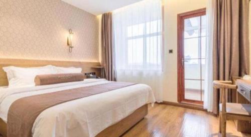 a hotel room with a large bed and a window at James Joyce Coffetel Qufu Tourist Center Gulou Street Sankong Scenic Spot in Jining
