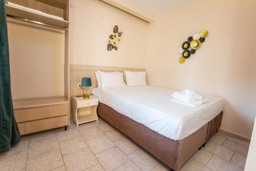 a small bedroom with a bed and a small cabinet at Psarotherma Rooms in Samothraki