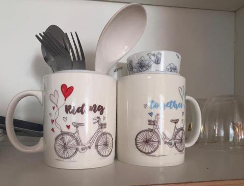 two mugs with a bike on them on a counter at Family Haven Serin West Tagaytay - 6 Pax - Taal View - Full Kitchen - FAST Wi-Fi in Tagaytay