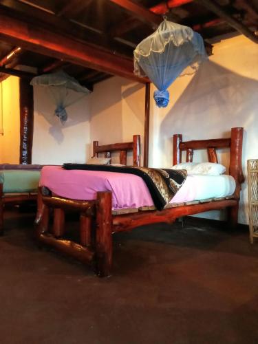 a bedroom with two wooden beds in a room at The Paulwood cabana home stay in Nuwara Eliya
